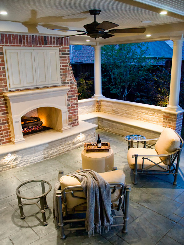 Réalisation d'un porche d'entrée de maison arrière tradition avec une cheminée, des pavés en pierre naturelle et une extension de toiture.
