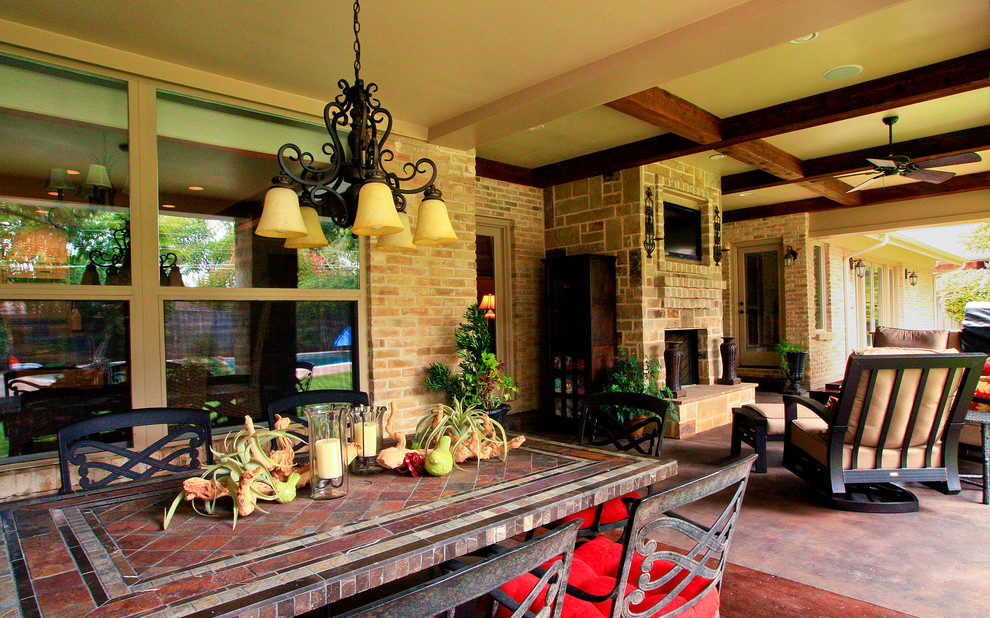 Large traditional back veranda in Dallas with a fire feature and concrete paving.