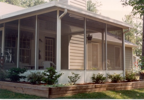 Photo of a large traditional back screened veranda in Charlotte with tiled flooring and an awning.