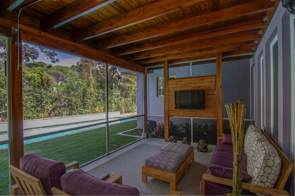 Diseño de porche cerrado tropical grande en patio lateral y anexo de casas con losas de hormigón
