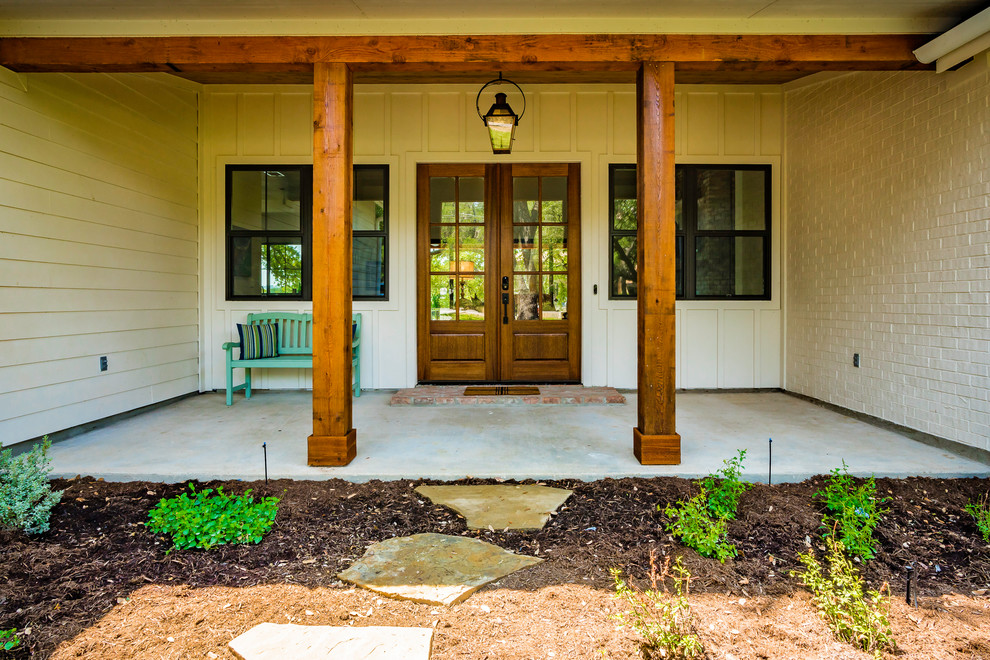 Inspiration for a medium sized farmhouse front veranda in Austin with concrete slabs and a roof extension.
