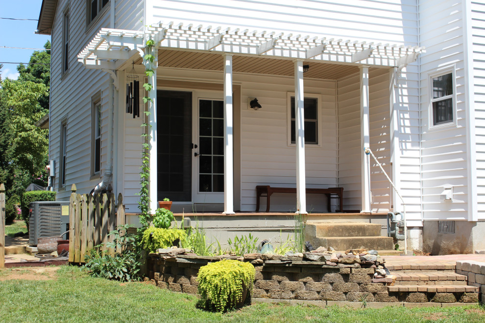 Photo of a medium sized back veranda in Other with with columns, brick paving and a pergola.