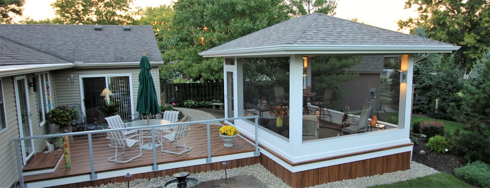Medium sized contemporary back screened veranda in Other with decking and a roof extension.