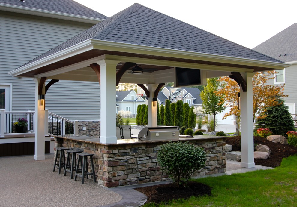 Idee per un portico tradizionale di medie dimensioni e dietro casa con cemento stampato e un tetto a sbalzo