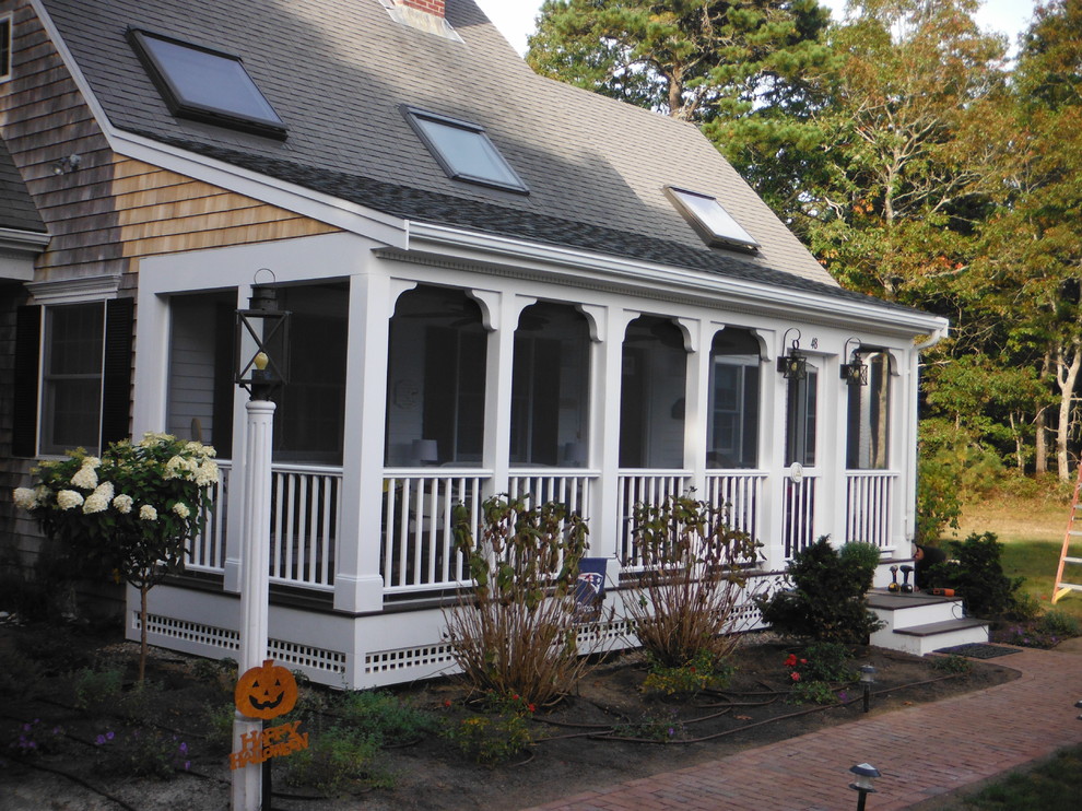 This is an example of a mid-sized traditional front porch design in Boston with a roof extension.