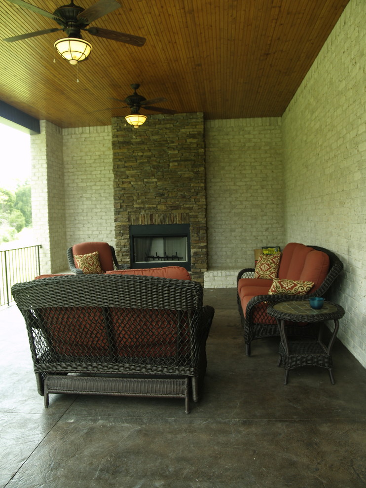 Idée de décoration pour un porche d'entrée de maison arrière tradition avec du béton estampé et une extension de toiture.