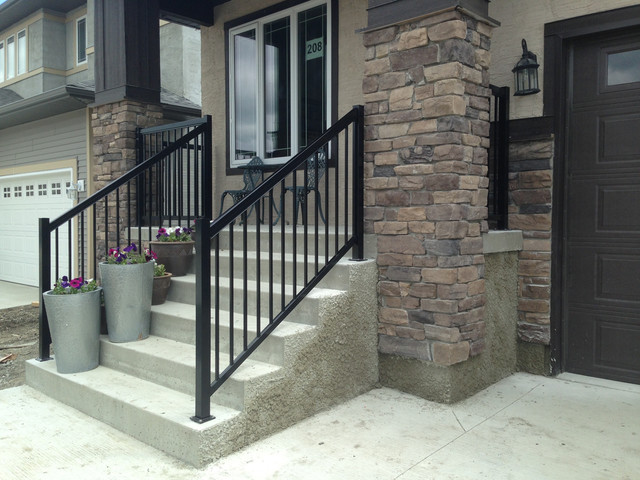 This is an example of a traditional stone front porch design in Other with a roof extension.
