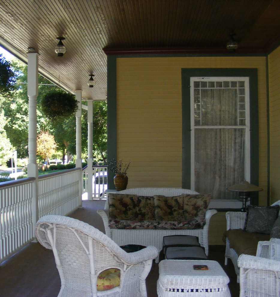 Ejemplo de terraza tradicional grande en patio delantero y anexo de casas con entablado, barandilla de varios materiales y zócalos