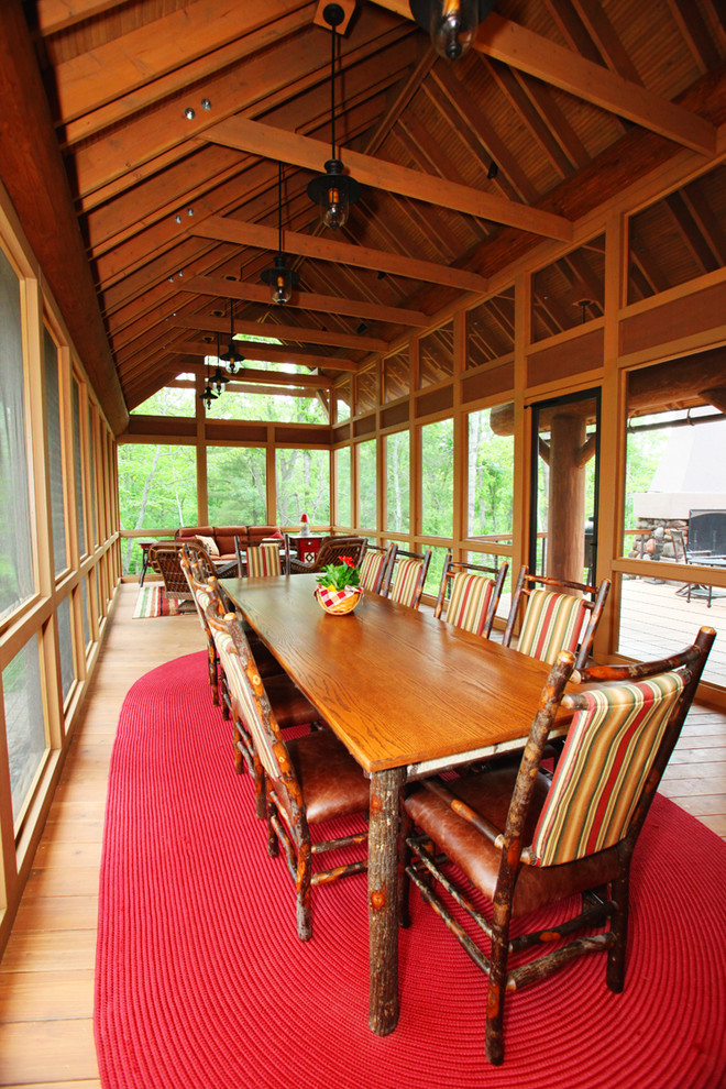 Inspiration for a huge rustic screened-in back porch remodel in Minneapolis with decking and a roof extension