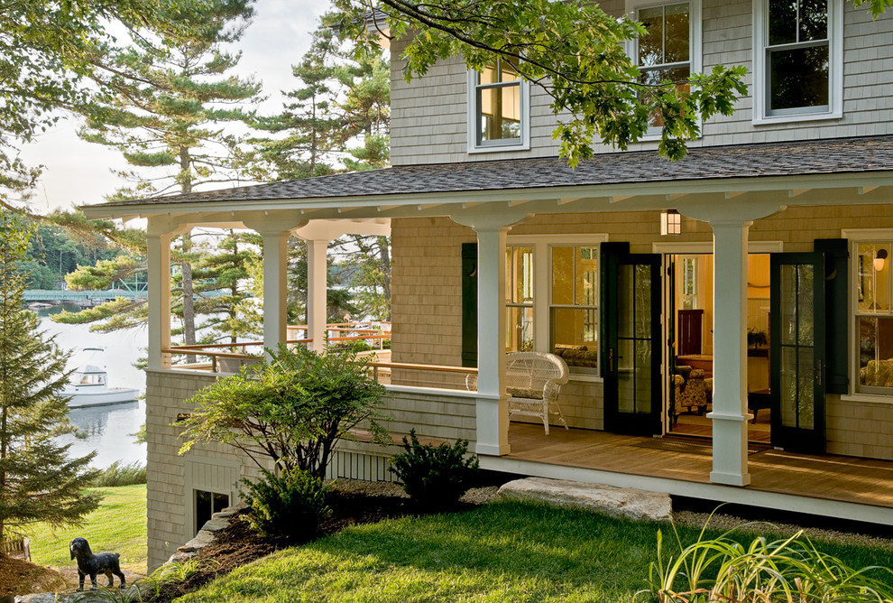 This is an example of a coastal porch design in Portland Maine with decking and a roof extension.