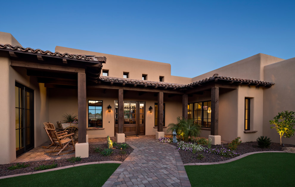 Inspiration for a southwestern concrete paver front porch remodel in Phoenix with a roof extension