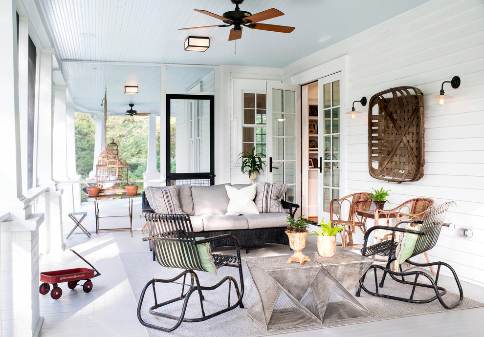 Cette photo montre un grand porche d'entrée de maison arrière chic avec une moustiquaire, une terrasse en bois et une extension de toiture.