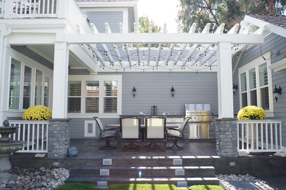 Example of a mid-sized ornate backyard concrete patio kitchen design in Denver with a pergola