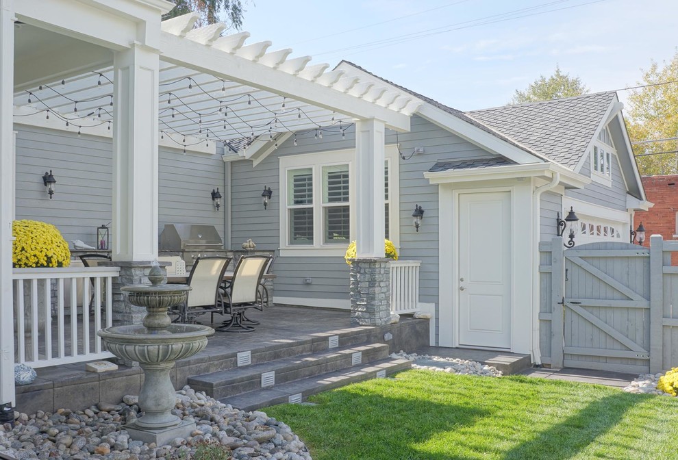 Immagine di un portico stile marino di medie dimensioni e dietro casa con lastre di cemento e una pergola
