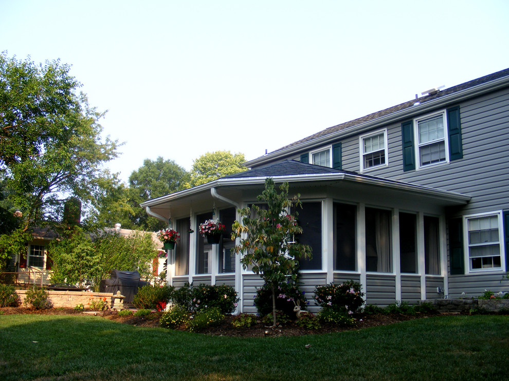 Foto på en mellanstor vintage veranda på baksidan av huset, med marksten i tegel och takförlängning