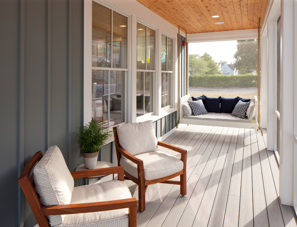 Idée de décoration pour un porche d'entrée de maison marin avec une terrasse en bois, une extension de toiture et une moustiquaire.