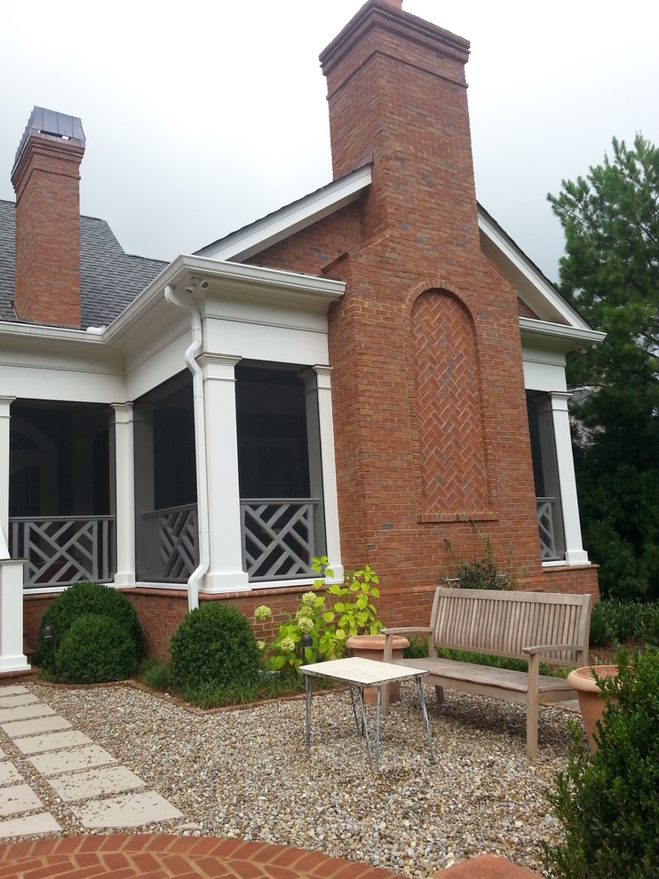 Idéer för att renovera en stor vintage innätad veranda på baksidan av huset, med marksten i tegel och takförlängning