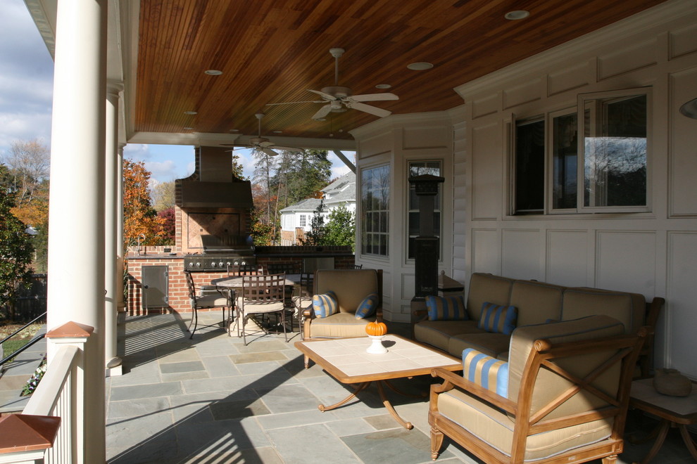Inredning av en klassisk mellanstor veranda, med utekök, naturstensplattor och takförlängning