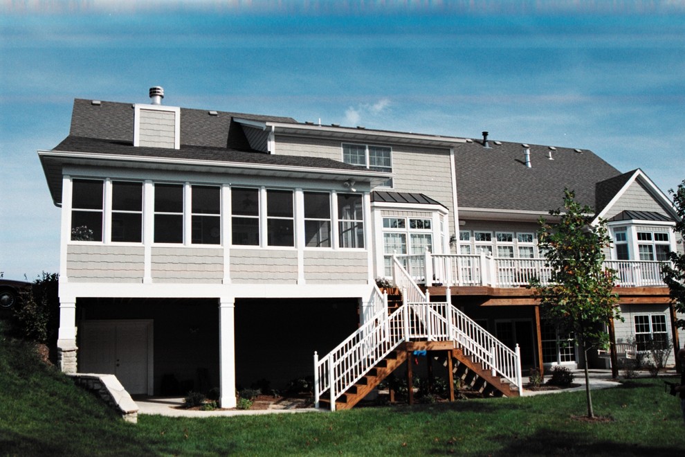 Exempel på en stor maritim innätad veranda på baksidan av huset, med trädäck och takförlängning