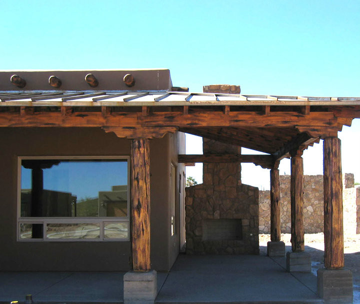 Inspiration for a small rustic front veranda in Phoenix with a fire feature, concrete slabs and a roof extension.