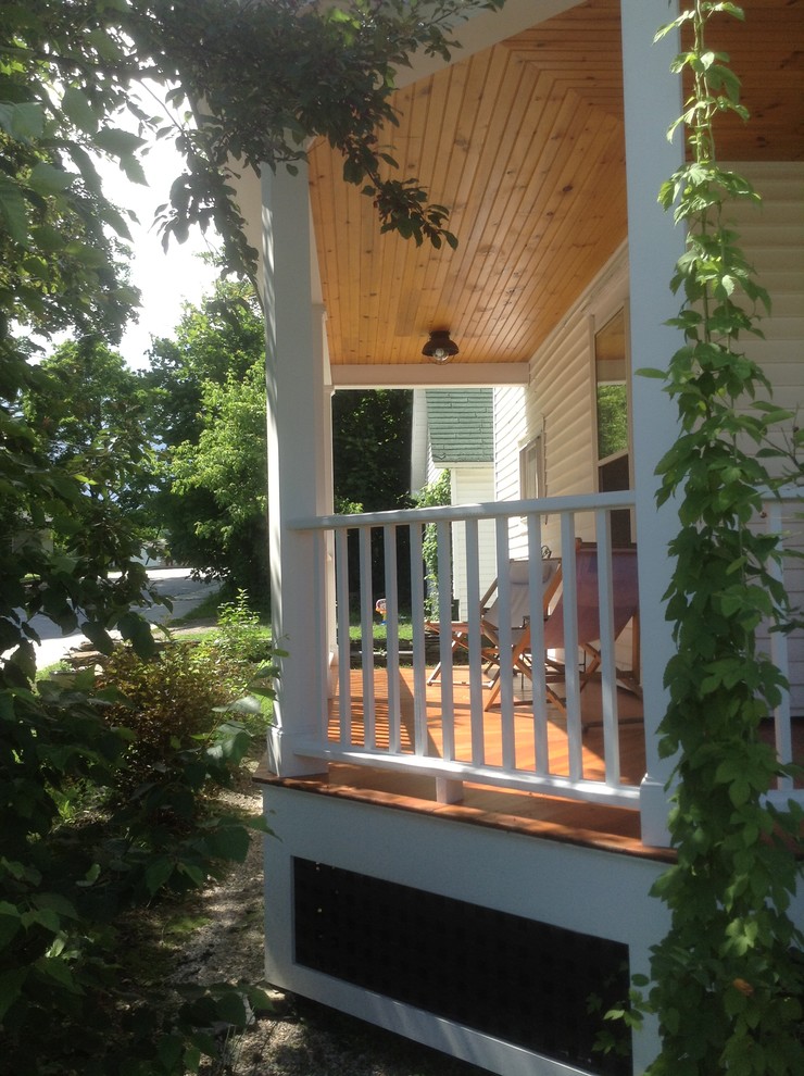 Inredning av en klassisk mellanstor veranda framför huset, med trädäck och takförlängning