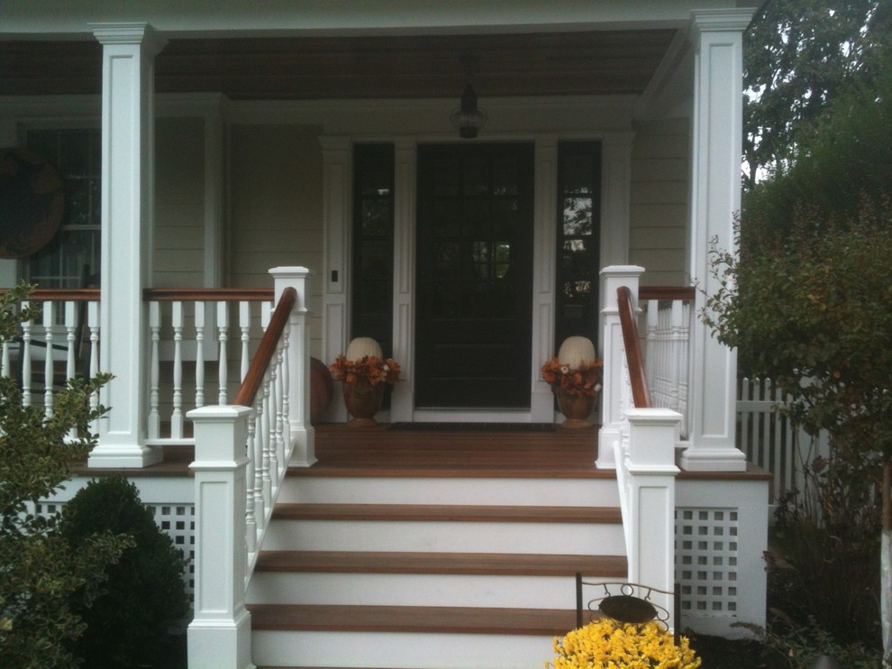 This is an example of a small transitional front porch design in New York with decking and a roof extension.