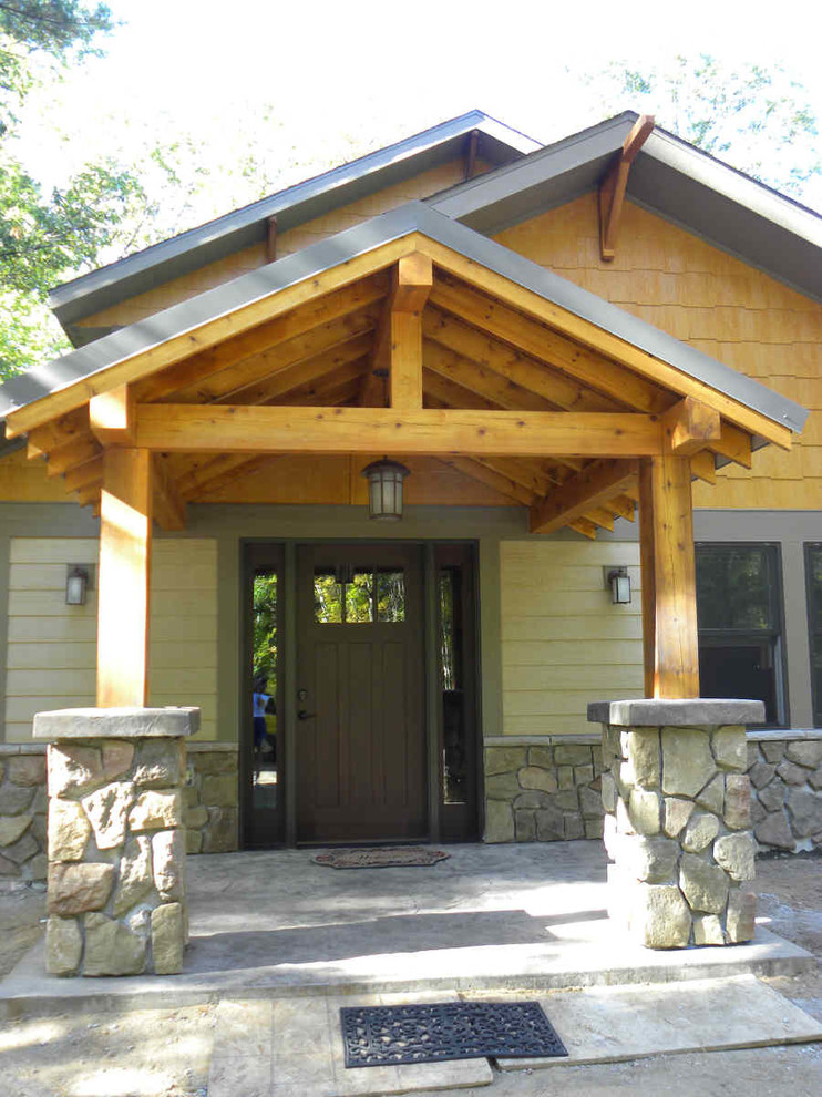 Inspiration pour un grand porche d'entrée de maison avant traditionnel avec une dalle de béton et une extension de toiture.