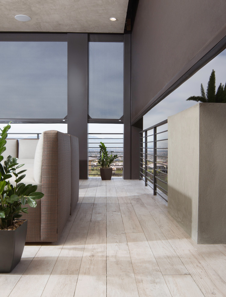 Modelo de terraza moderna grande en patio trasero y anexo de casas con suelo de baldosas y brasero