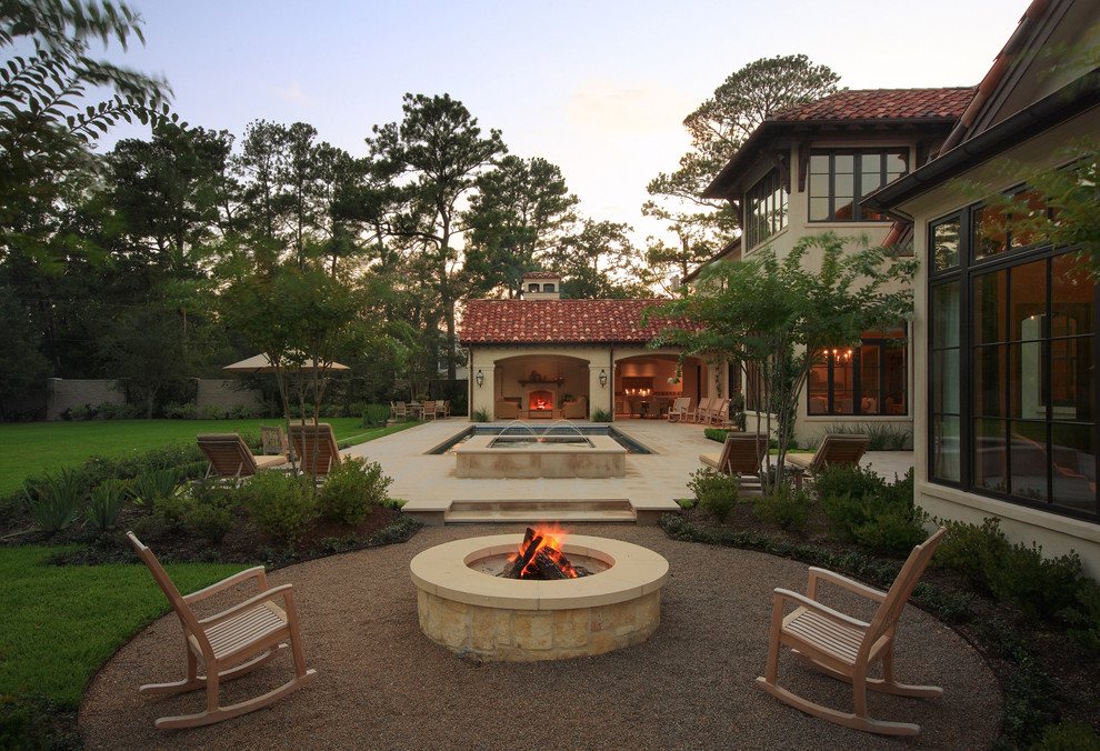 Photo of an expansive mediterranean back veranda in Houston with a fire feature and tiled flooring.