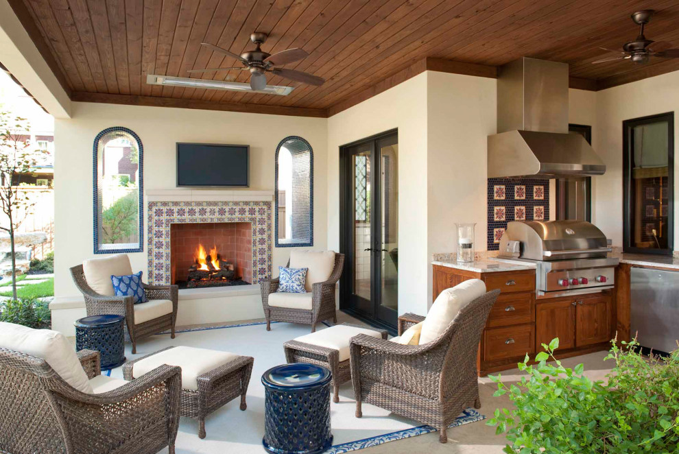 This is an example of a mediterranean back veranda in Dallas with a fireplace and a roof extension.