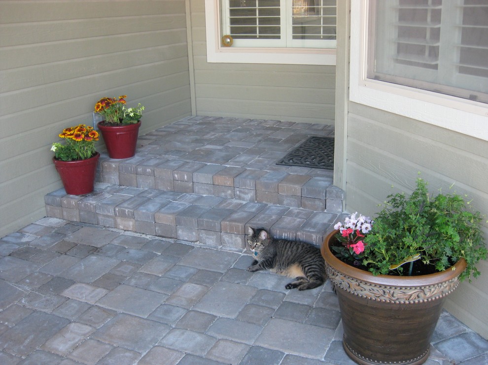 Mid-sized classic concrete paver front porch idea in Boise with a roof extension