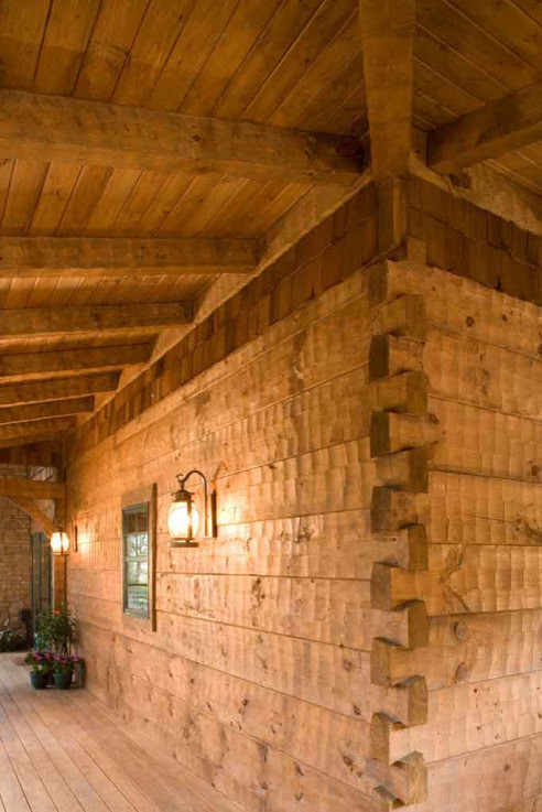 Idée de décoration pour un petit porche d'entrée de maison avant chalet avec une terrasse en bois et une extension de toiture.