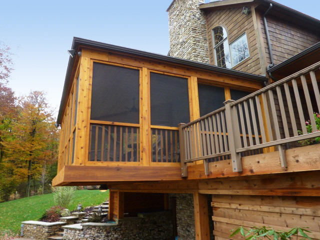 Aménagement d'un grand porche d'entrée de maison arrière montagne avec une moustiquaire, une terrasse en bois et une extension de toiture.