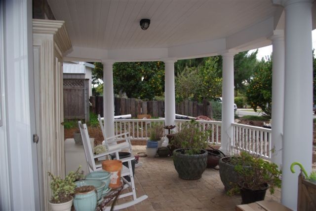 Medium sized farmhouse front veranda in San Diego with brick paving and a roof extension.