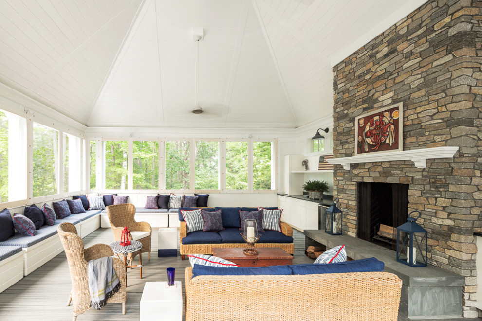 Beach style porch idea in Portland Maine with a roof extension and a fireplace