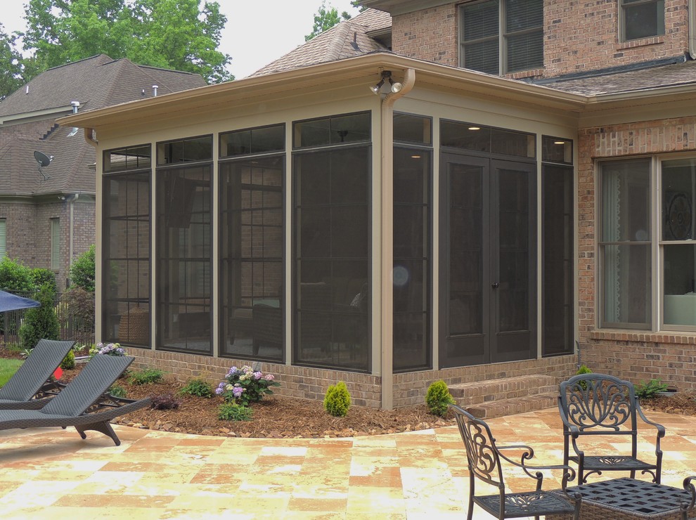 Inspiration for a large classic back screened veranda in Charlotte with stamped concrete and a roof extension.