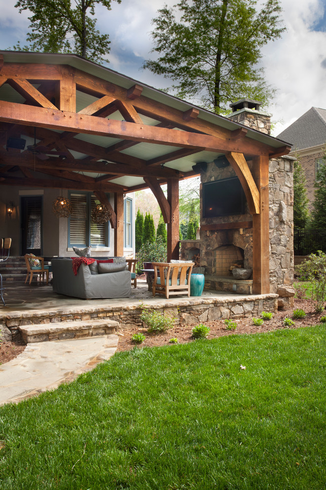 Idée de décoration pour un grand porche d'entrée de maison arrière tradition avec une cuisine d'été, des pavés en pierre naturelle et une extension de toiture.