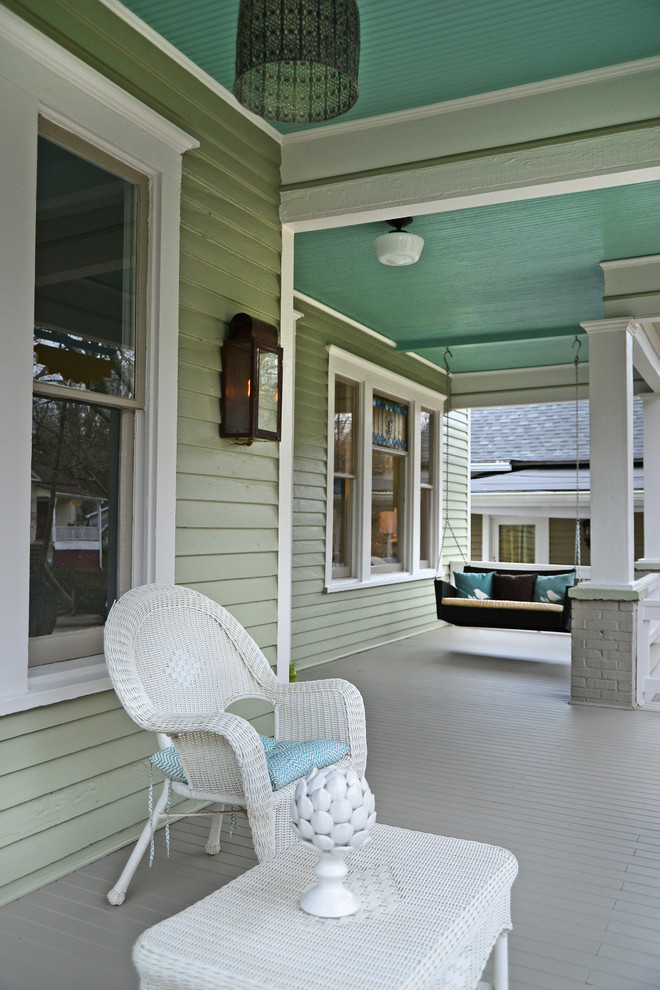 Foto på en vintage veranda framför huset, med trädäck och takförlängning