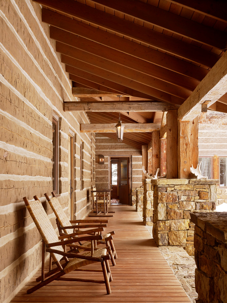 Idée de décoration pour un porche d'entrée de maison chalet avec une terrasse en bois.