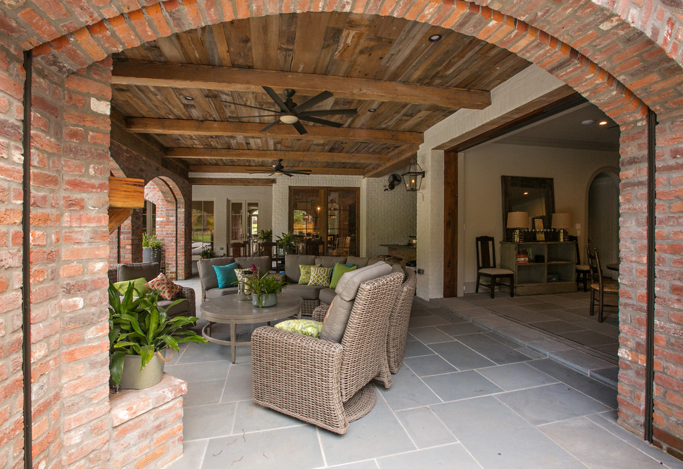 Idée de décoration pour un grand porche d'entrée de maison arrière chalet avec une extension de toiture et du carrelage.