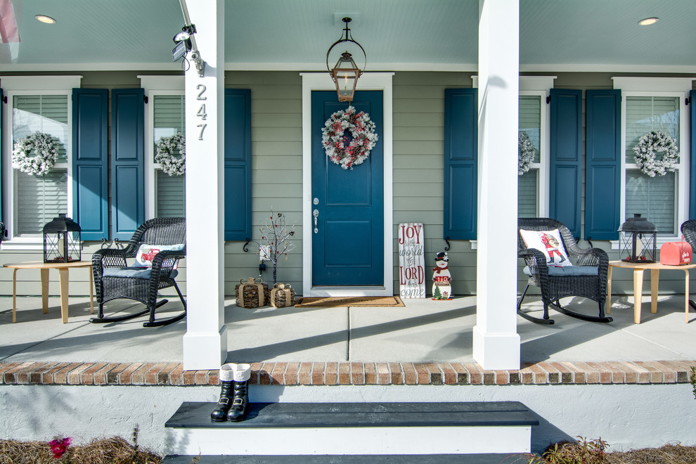 Cette photo montre un porche d'entrée de maison avant chic de taille moyenne avec une dalle de béton et une extension de toiture.