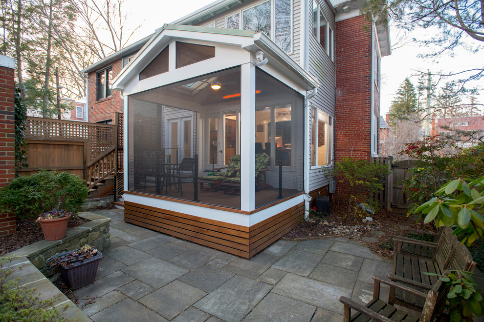 Cette photo montre un petit porche d'entrée de maison arrière moderne avec une moustiquaire et des pavés en béton.