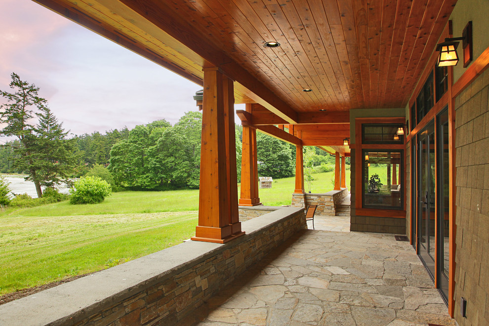 Idéer för mellanstora amerikanska verandor på baksidan av huset, med naturstensplattor och takförlängning