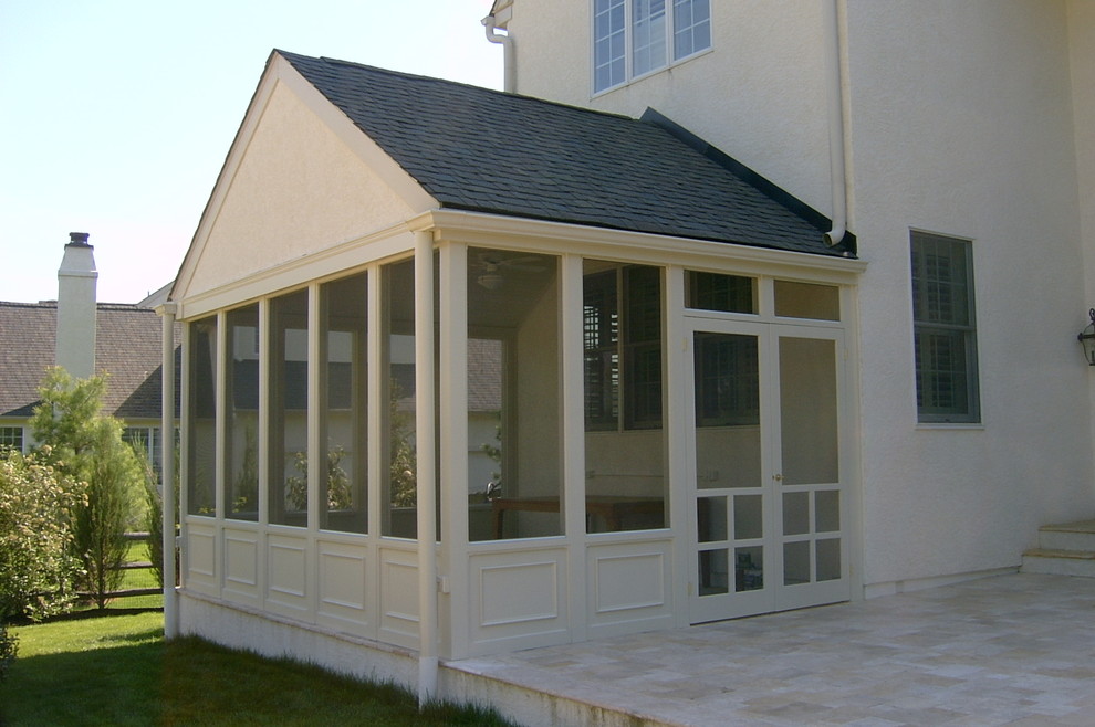 Cette image montre un porche d'entrée de maison arrière design de taille moyenne avec une moustiquaire, des pavés en pierre naturelle et une extension de toiture.