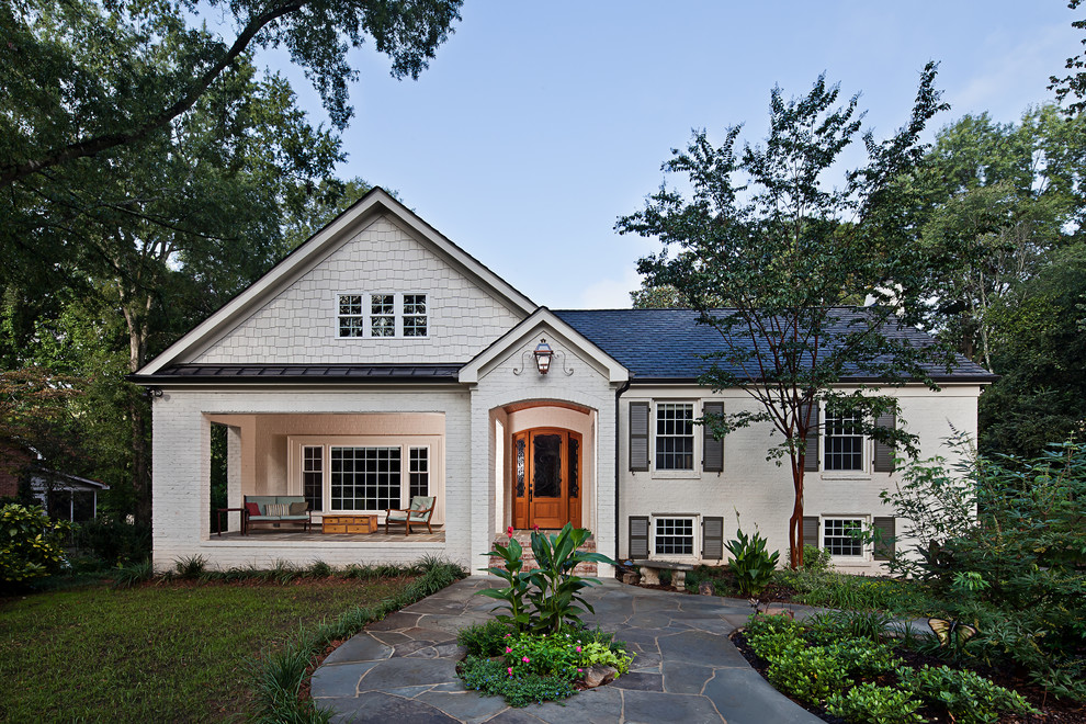 Réalisation d'un porche d'entrée de maison avant tradition de taille moyenne avec des pavés en pierre naturelle et une extension de toiture.