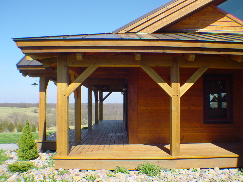 Foto på en mellanstor rustik veranda framför huset, med trädäck och takförlängning