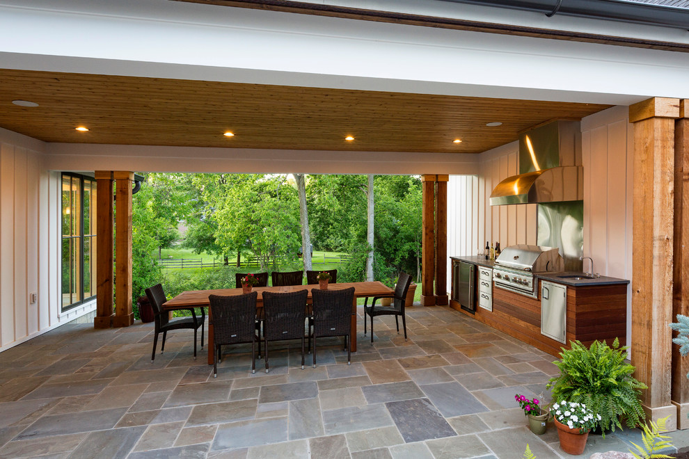 Cette image montre un porche d'entrée de maison arrière rustique avec une cuisine d'été, des pavés en pierre naturelle et une extension de toiture.