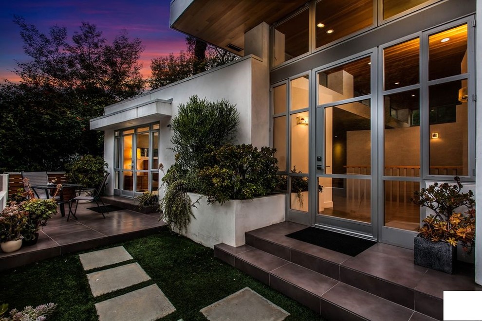 Mid-sized transitional concrete paver porch photo in Los Angeles with an awning