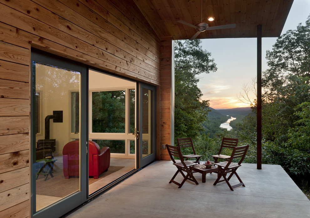 Inspiration för små moderna innätade verandor på baksidan av huset, med betongplatta och takförlängning