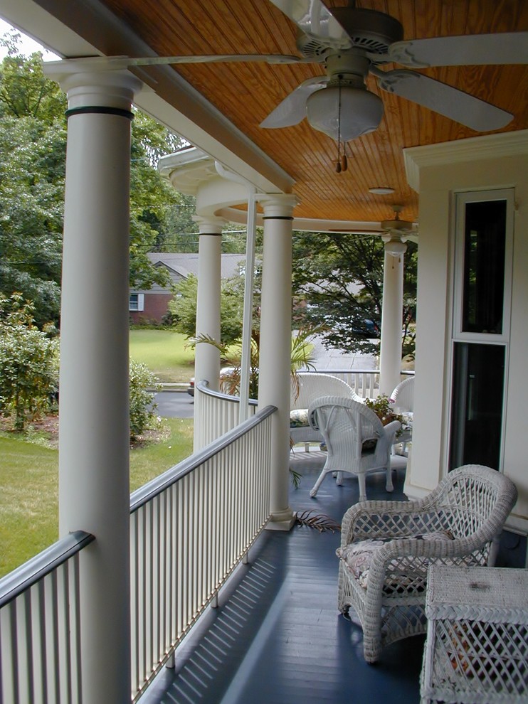 Idée de décoration pour un grand porche d'entrée de maison latéral tradition avec une terrasse en bois et une extension de toiture.